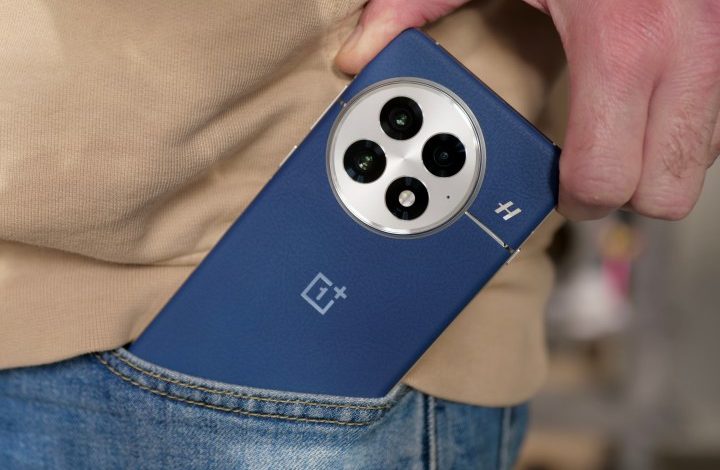 A person taking the OnePlus 13 out of a pocket.