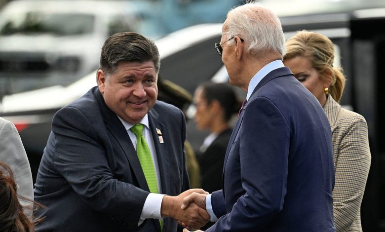 President Joe Biden, right, is greeted by Illinois Gov. JB Pritzker