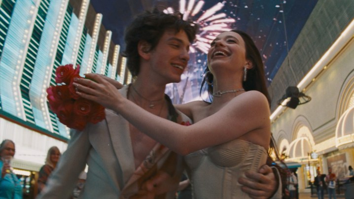 Mark Eydelshteyn and Mikey Madison dance against a blur of Las Vegas lights in a shot from the movie Anora.