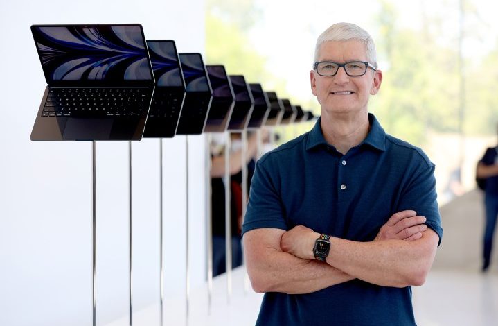 Apple CEO Tim Cook looks at a display of brand new redesigned MacBook Air laptop during the WWDC22