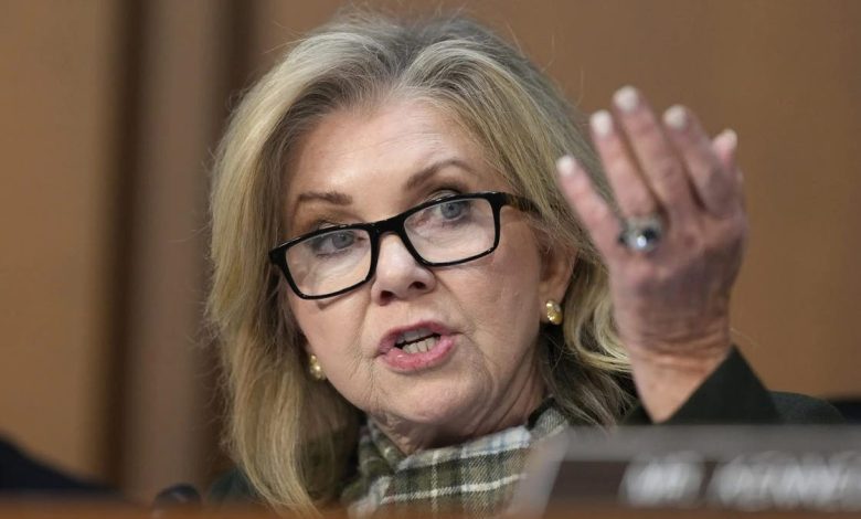 Sen Blackburn lifts her hand while asking a question during a Senate hearing for FBI director nominee Kash Patel