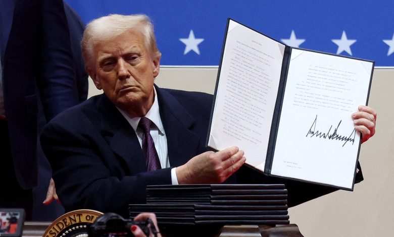 U.S. President Donald Trump shows his signature on an executive order