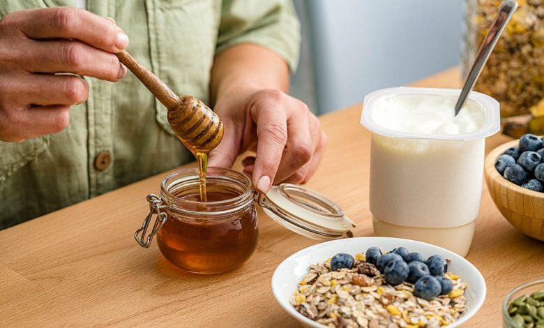 healthy breakfast with honey, berries, seeds, granola and yogurt.