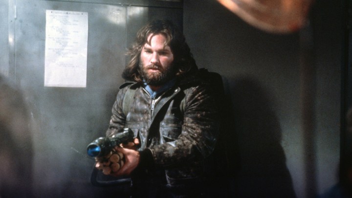 A young Kurt Russell holding a gun in the movie The Thing.