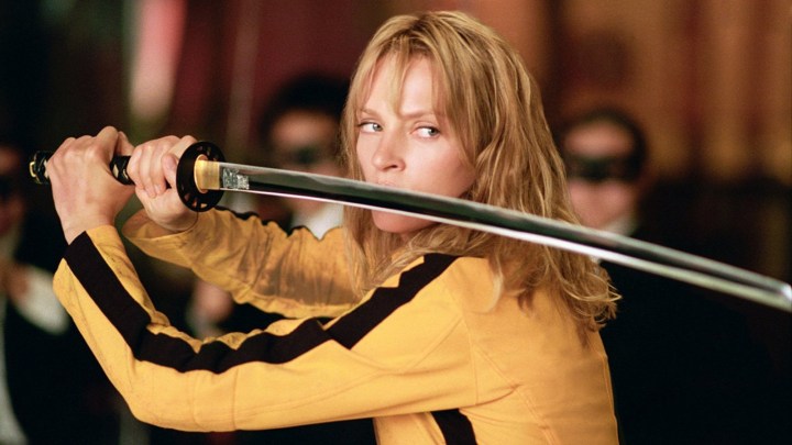 The Bride holds a sword up by her face, looking angry in Kill Bill: Vol. 1