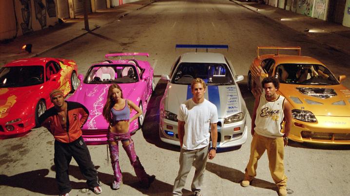 4 people stand in front of 4 cars in 2 Fast 2 Furious.