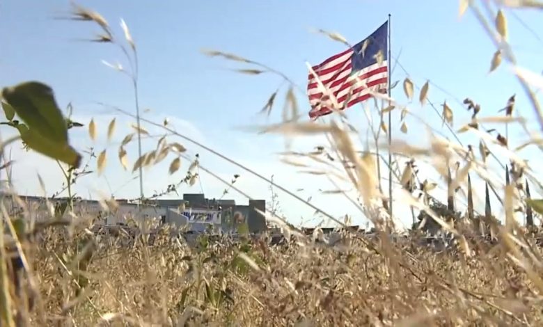 A giant U.S. flag flies atop a 130-foot-tall flag pole outside RV retailer Camping World's French Camp, California.