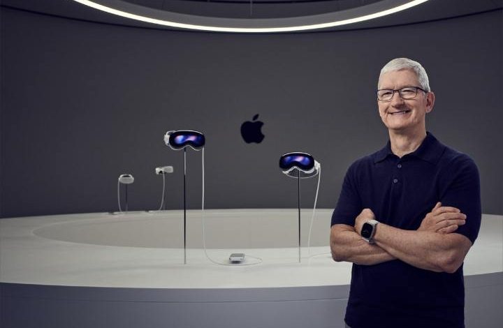 Apple CEO Tim Cook standing in front of four Vision Pro headsets.