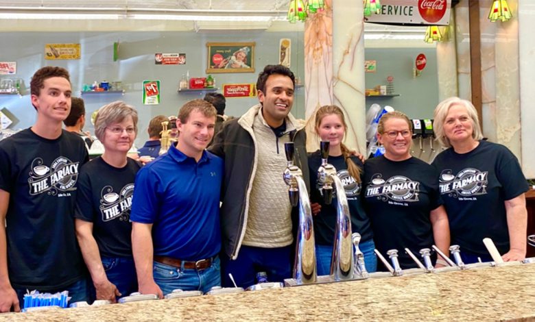 Vivek Ramaswamy in the center with arms around supporters in Iowa smiling