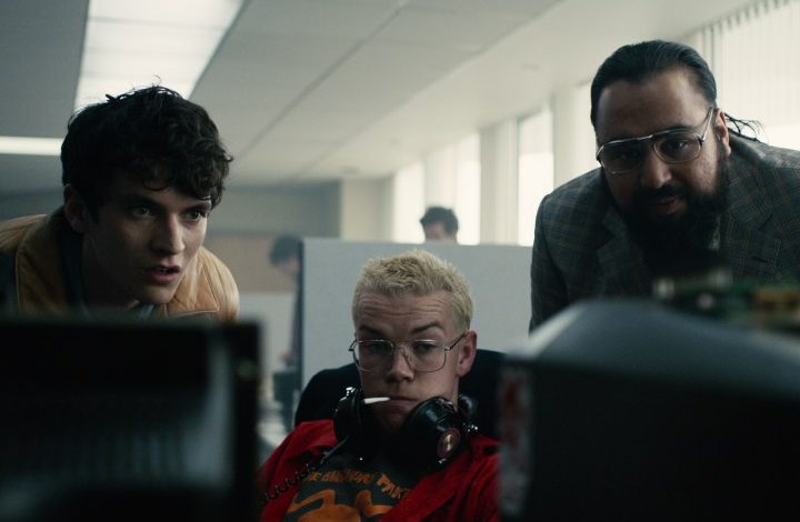 Three men crowd around a computer in Bandersnatch.