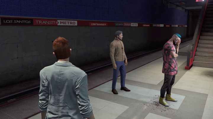 Inside of a subway station a figure with short red hair wearing a light blazer watches a figure with a tan jacket and blue jeans talk to a figure with blue hair and a red leaf print shirt who is holding his hand to his face.