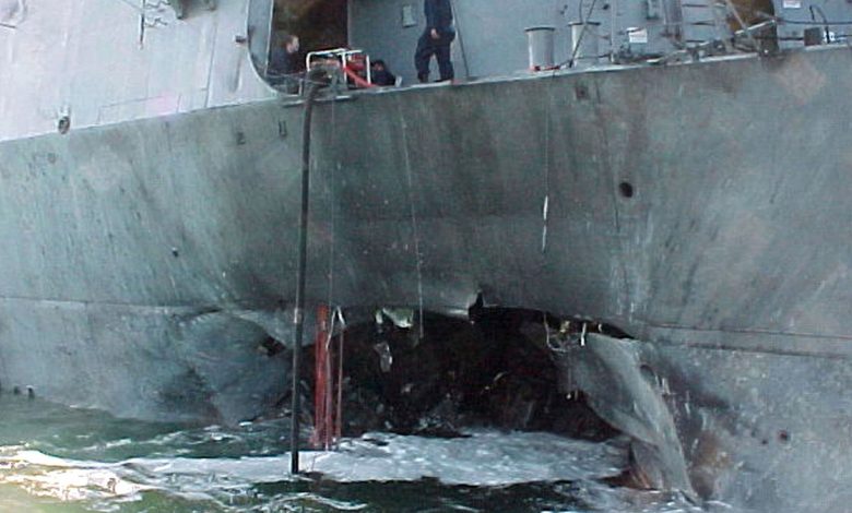 A gaping hole mars the port side of the Arleigh Burke class guided missile destroyer USS Cole