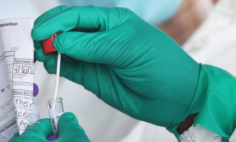 A Health Care Worker seals a coronavirus swab