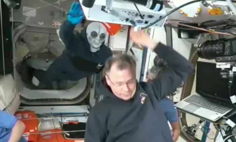 Russian cosmonaut Ivan Vagner wears alien mask while welcoming newcomers