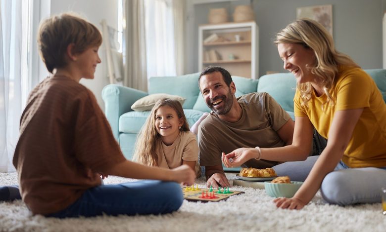 Family playing games together on the carpet.