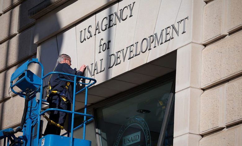 Worker removes signage from the USAID building in Washington, D.C.