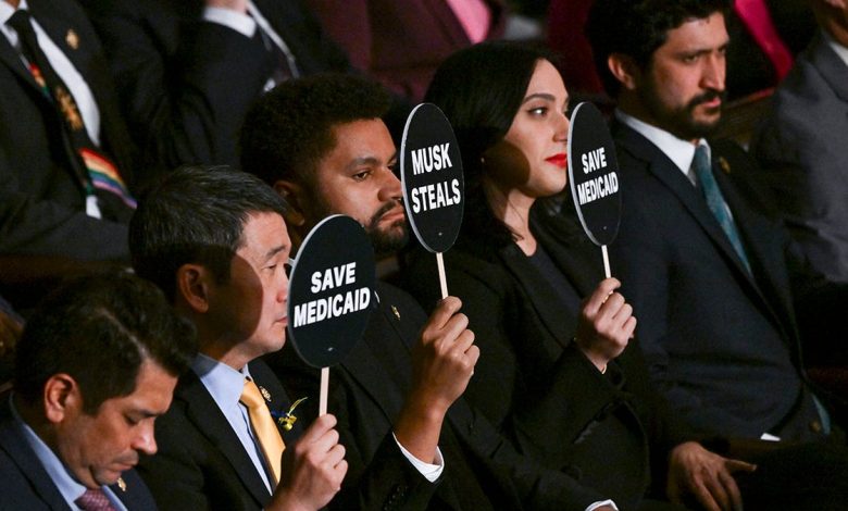 Democrats holding anti-Trump protest signs in House chamber