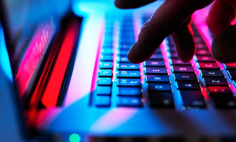 Man typing at his laptop computer at night