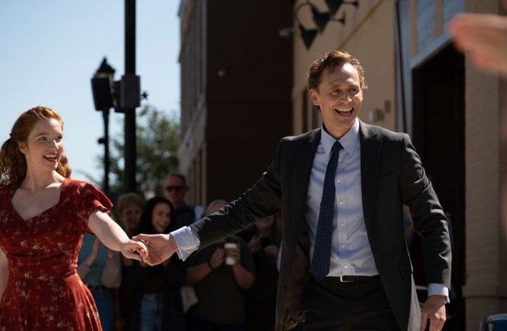 Tom Hiddleston holds a woman's hand.