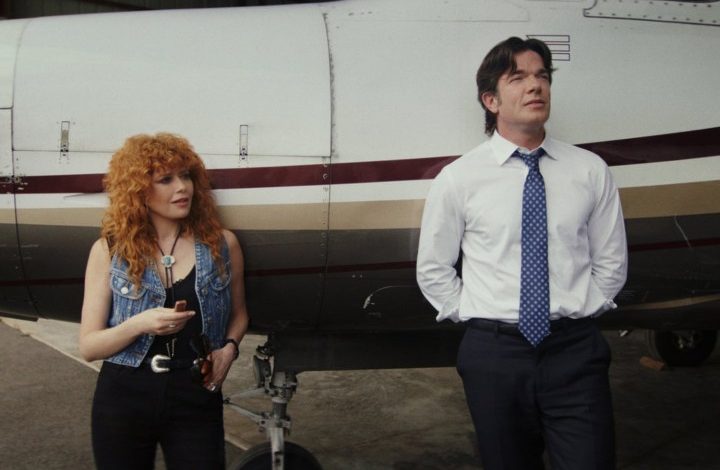 A woman and a man lean up against a plane.