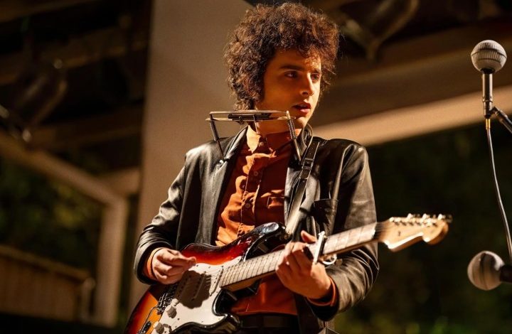 Timothee Chalamet plays the guitar and stares.