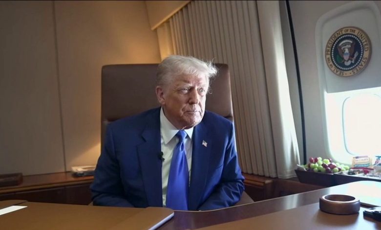 President Donald Trump sits in a chair at a desk aboard Air Force One.