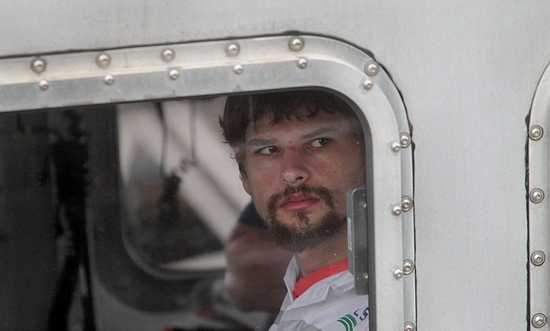 Nathan Carman looking away inside a boat.