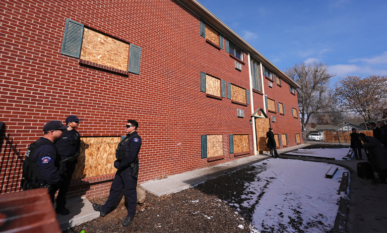 Officers gather outside one of the condemned buildings of an apartment complex called The Edge at Lowry