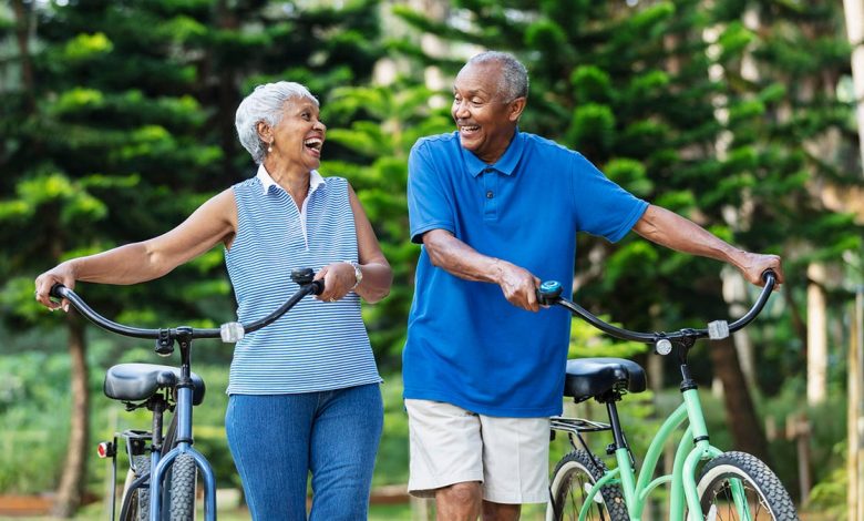 Senior couple walk with bikes, laughing
