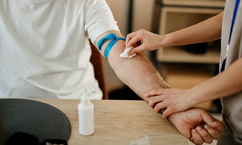 Nurse drawing blood from an elderly man