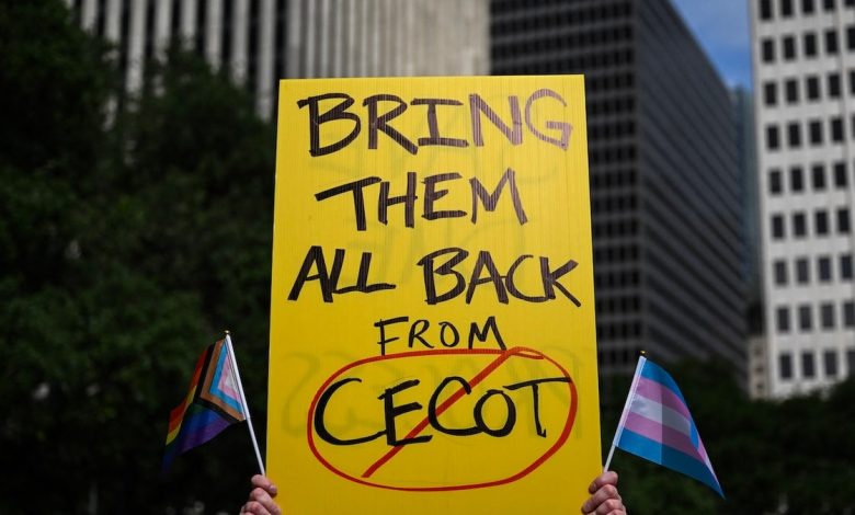 A person holds up a sign referencing the CECOT prison in El Salvador during a demonstration against President Donald Trump and his immigration policies in Houston on May 1, 2025.