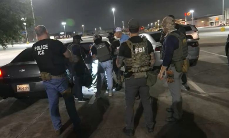 many police officials crowd car as they detain a man