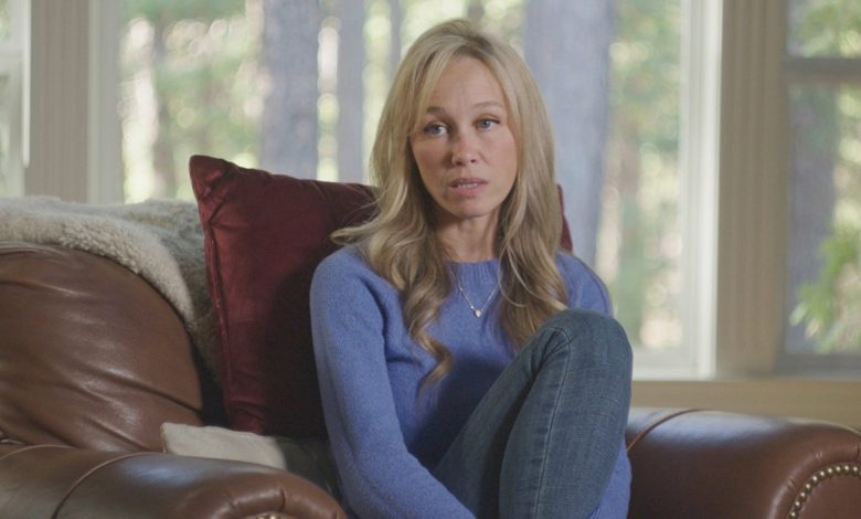 A close-up of Sherri Papini wearing a periwinkle sweater and jeans sitting on a couch.
