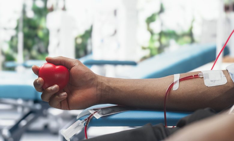 Close Up Shot Of Hand Of Male Blood Donor With an Attached Catheter. Black Man Holding Heart-Shaped Red Ball To Pump Blood Through The Tubing Into Bag. Donation For Organ Transplant Patients: new tests may be able to detect junk food consumption from blood and urine samples