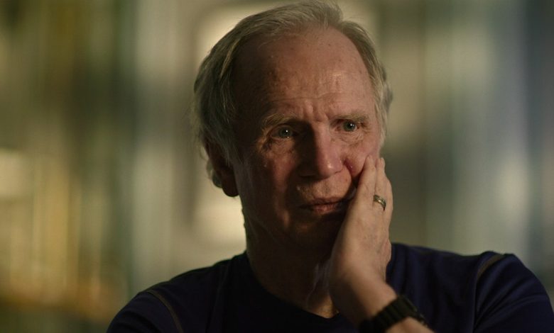 A close-up of James Lewis touching his face.