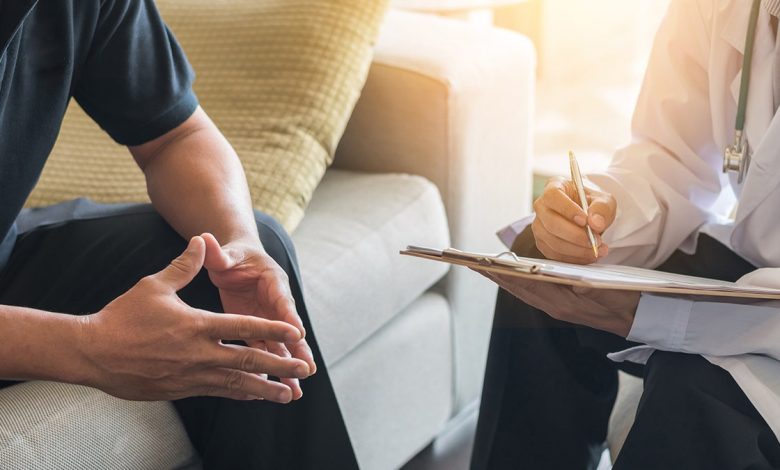 Doctor consulting male patient, working on diagnostic examination on men's health disease or mental illness, while writing on prescription record information document in clinic or hospital office. To be used in piece about prostate cancer screenings