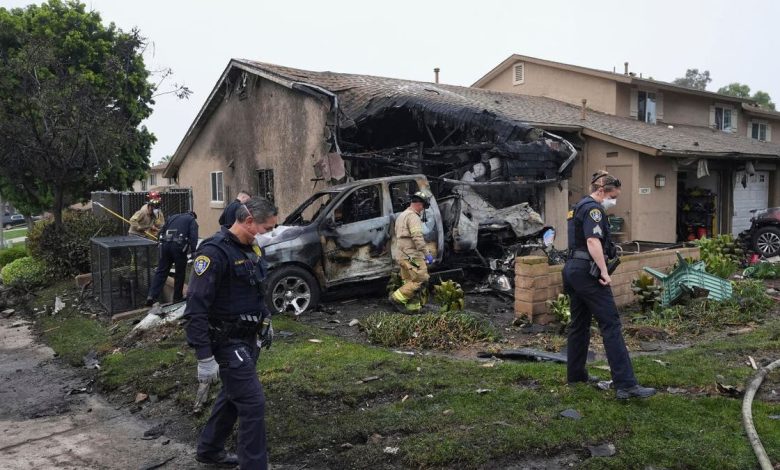Authorities work the scene of a house where a small plane crashed
