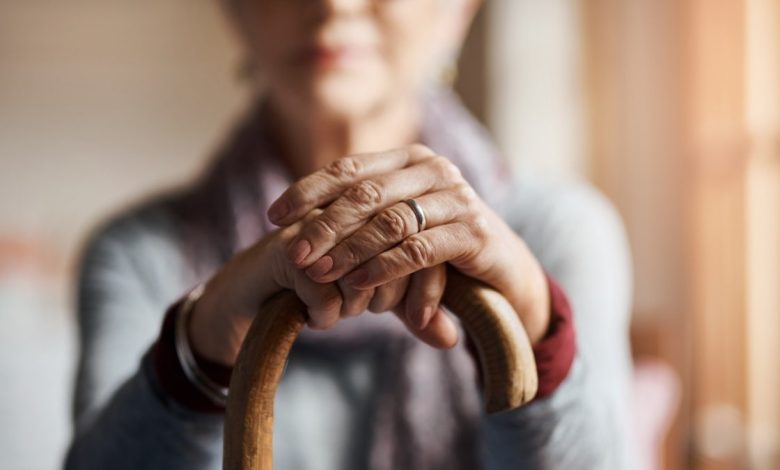 Older woman holding cane