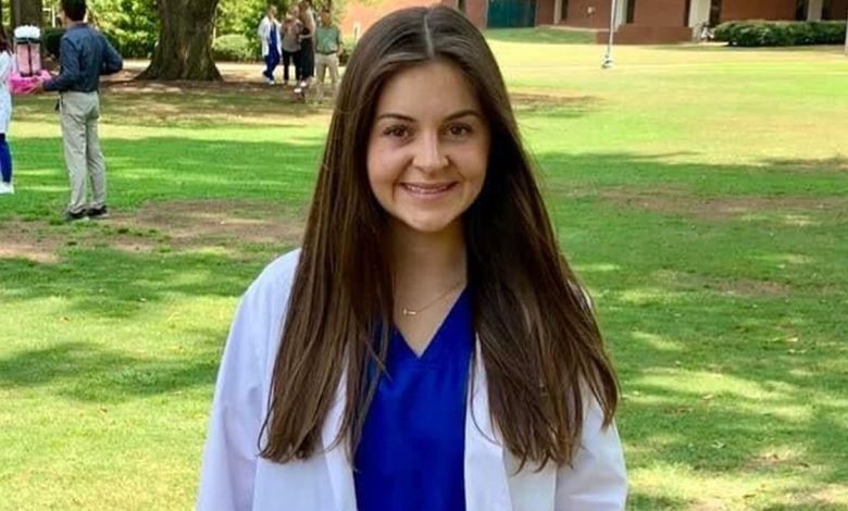 Laken Riley in a medical coat in a grassy field