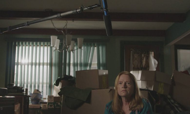 Asa Ellerup wearing a blue blouse and sitting in front of a mic over her head.