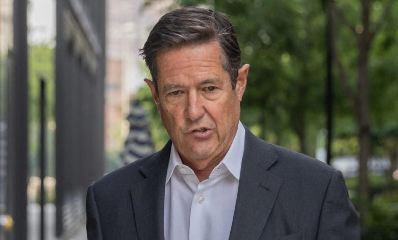 Jes Staley walks on a city block, wearing a suit and no tie