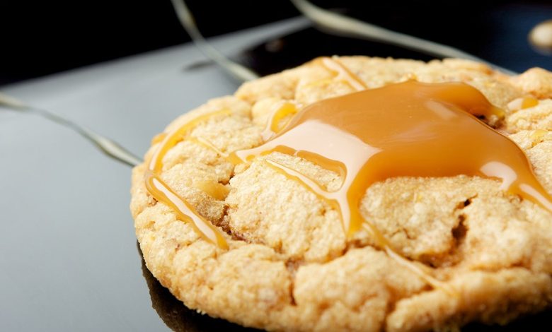 One peanut butter cookie with caramel drizzled on top. Close up shot. Selective focus.