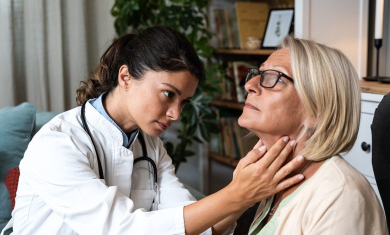 Doctor feels patient's throat.