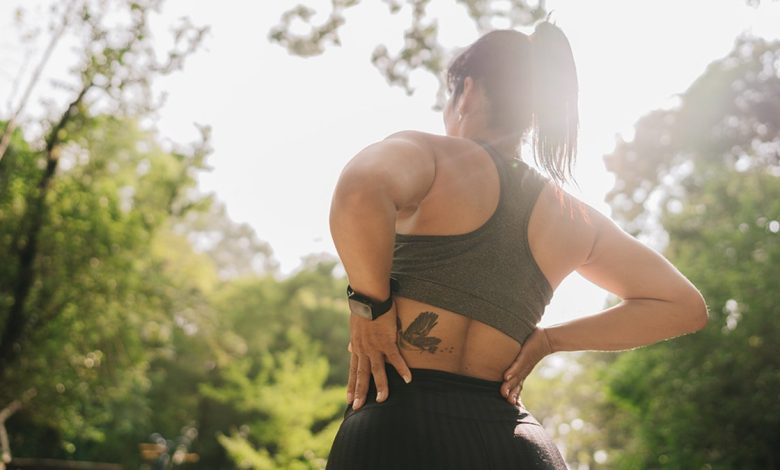 woman holding lower back outside