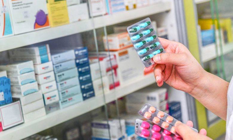 Hand holding medicine capsule pack at the pharmacy drugstore.