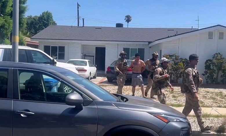 federal officials escort shirtless suspect from house to vehicle