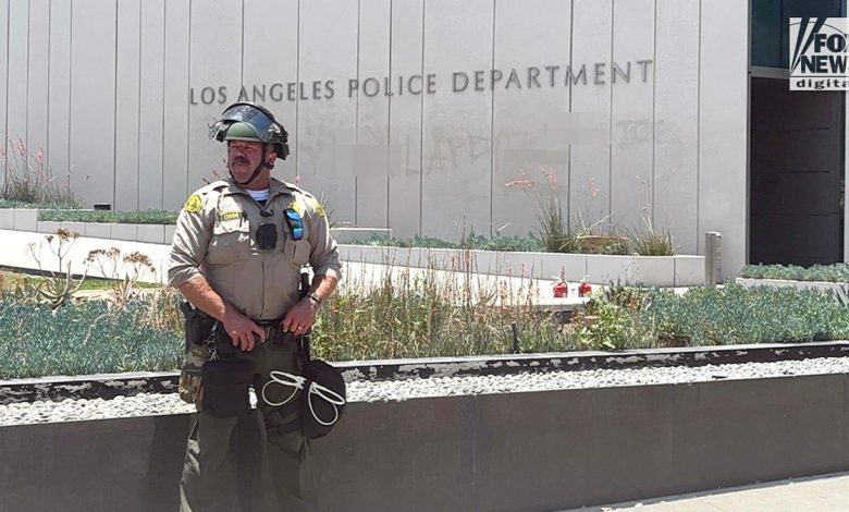 Los Angeles County Sheriff’s deputy stands guard outside LAPD headquarters amid civil unrest