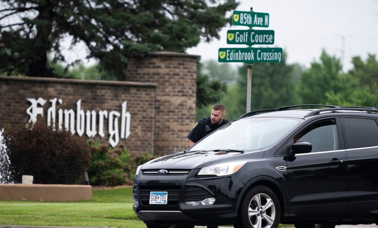 A police officer standing next to a car in front of a street sign