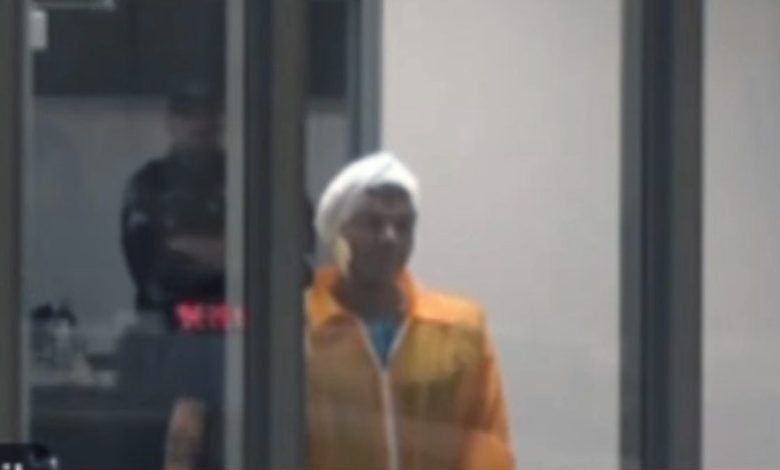 Mohamed Soliman in an orange jumpsuit