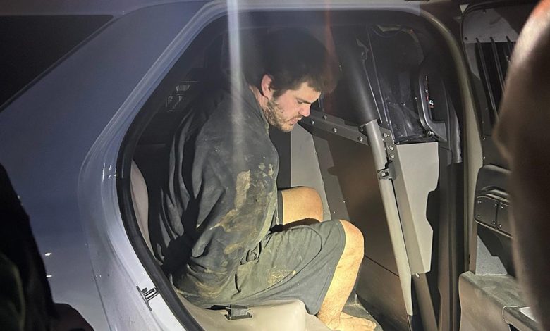 Trevor McEuen barefoot and handcuffed in the back of a cop car